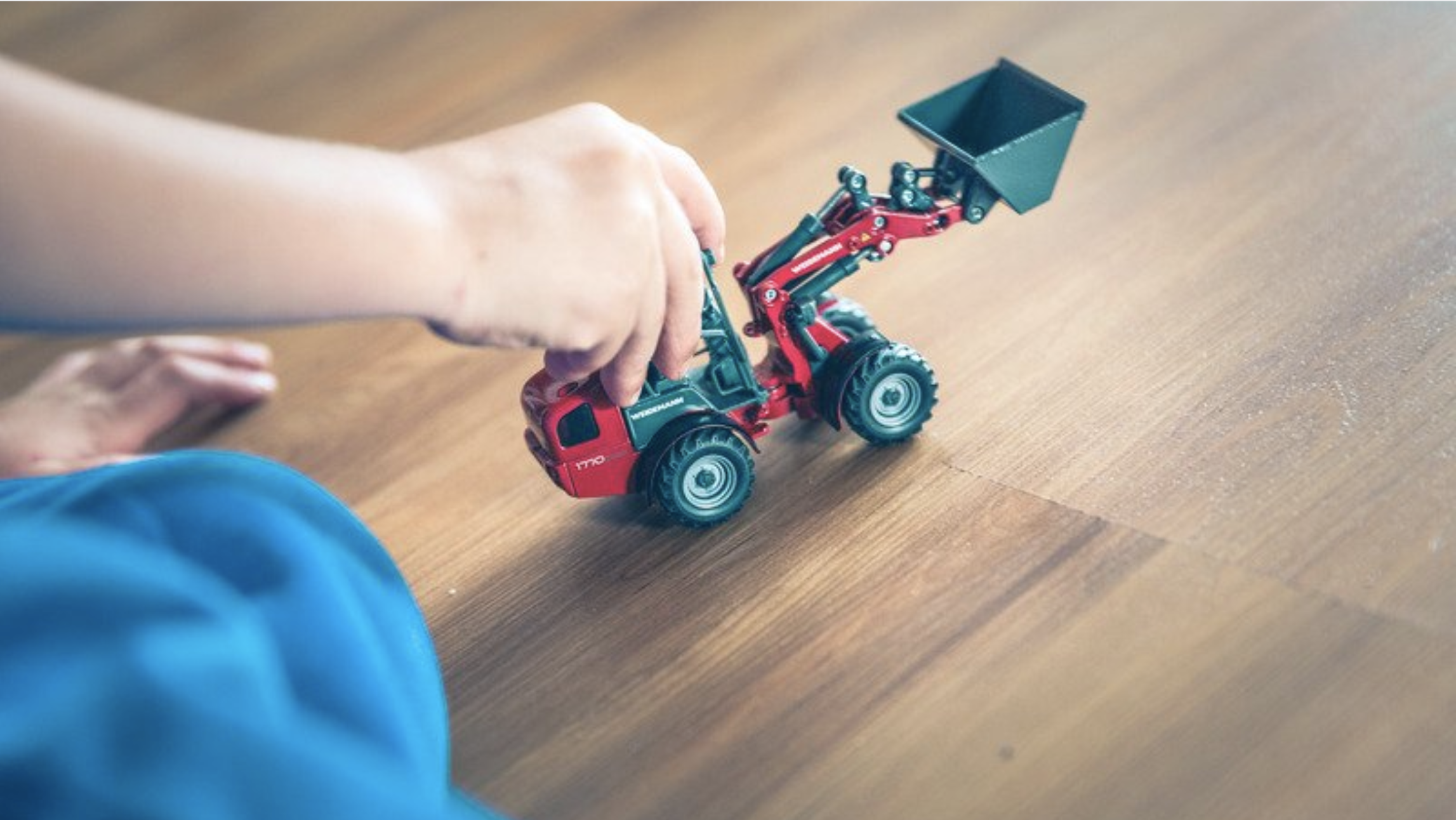 Kid's hand playing with a tractor